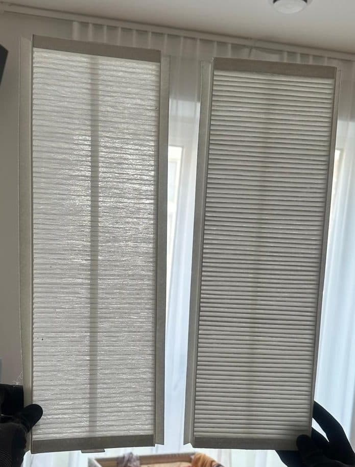 The same two HRV filters held up against a window, seen from further back